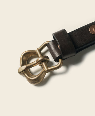 Brown leather belt with antique brass buckle, close-up
