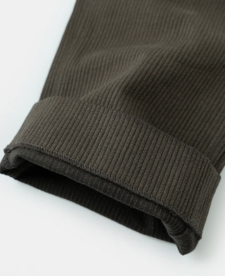 Rolled hem of dark coffee pique stripe cotton trousers with textured cuff.