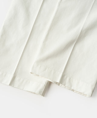 White cotton twill trouser hem with cuff and stitched vent.