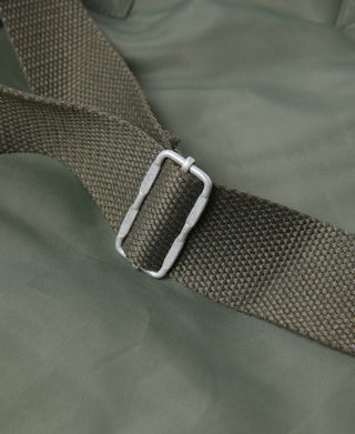 Olive webbing strap with metal D-ring on helmet bag