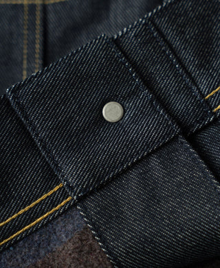 Indigo denim jacket sleeve cuff with metal snap and yellow contrast stitching