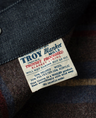 Indigo denim jacket interior label with printed sizing and fabric blend info