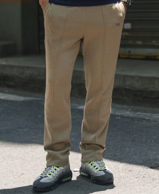 Khaki waffle knit jogger pants on model, elastic cuffs and taper