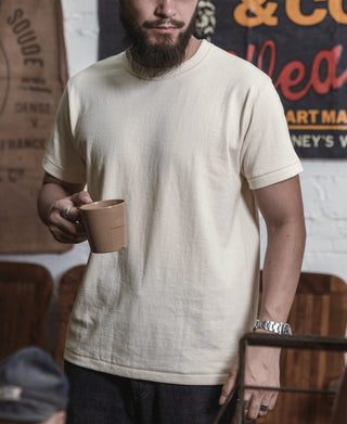 Apricot athletic T-shirt with crew neck and short sleeves on a standing model.