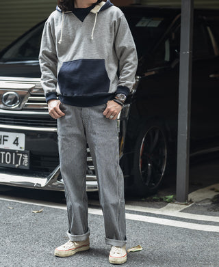Two-tone hooded sweatshirt, gray with navy hood and pocket, worn with jeans