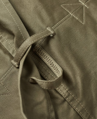 Khaki green jacket sleeve placket with buttoned flap and fabric strap detail