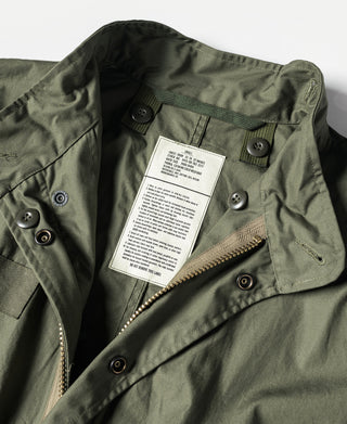 Olive parka with taped label, snap buttons, and zippered chest pocket