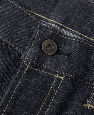Selvedge denim jeans front yoke with copper-tone button and contrast topstitching