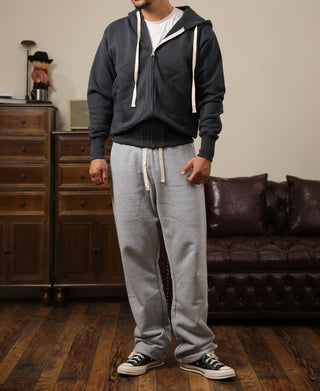 Gray terry sweatpants with drawstring waist, side pockets, and relaxed tapered fit