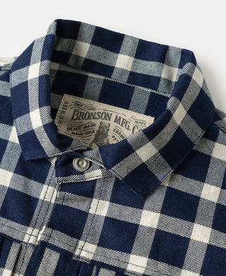 Plaid work jacket interior neck label and buttoned collar close-up