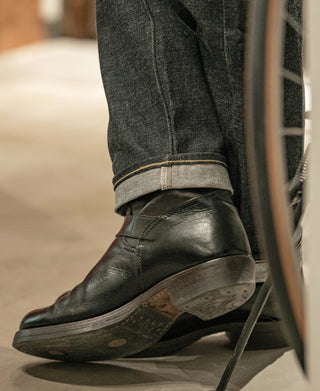 Prewashed selvedge denim jeans with cuffed hem showing orange selvedge thread; straight leg
