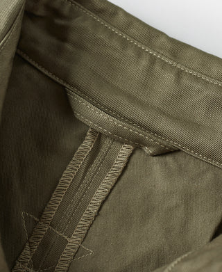 Khaki green jacket interior seam with stitched tab and folded fabric pocket edge