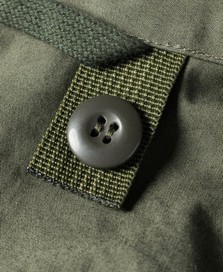 Olive parka snap button on stitched fabric tab with bar-tack edges