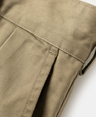 Close-up of khaki side seam and pleat at pocket opening.