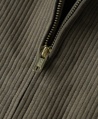Close-up of dark olive jacket zipper with metal pull and striped fabric texture