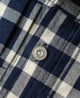 Plaid work jacket cuff with metal snap button close-up
