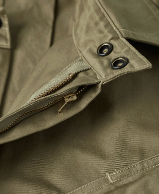 Khaki green jacket pocket flap with snap buttons and brass zipper pull