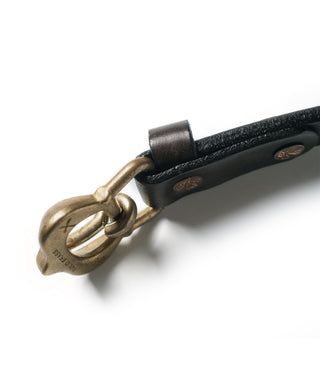 Brown leather belt strap with antique brass buckle, close-up