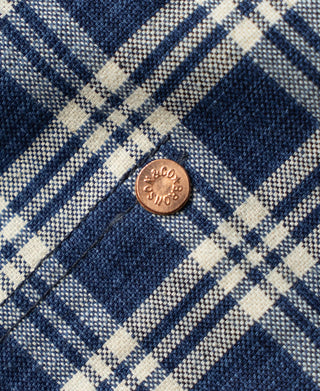 Blue plaid work jacket fabric close-up with metal button detail