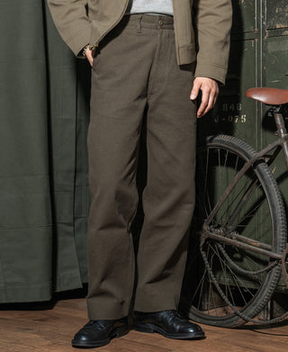 Coffee-brown striped work trousers with straight leg and side pockets, worn