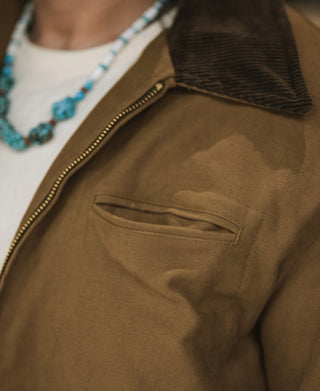 Brown jacket chest pocket and visible houndstooth lining at collar